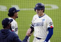 　エンゼルス戦の１回、この回２度目の打席で11号２ランを放ち、ベンチ前で祝福されるドジャース・大谷＝ロサンゼルス（共同）