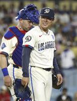 　エンゼルス戦の８回を投げ終え、笑顔でベンチに戻るドジャース・山本。左は捕手ラッシング＝ロサンゼルス（共同）