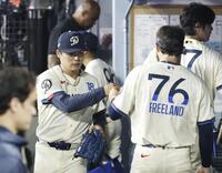 　エンゼルス戦の８回を投げ終え、ベンチでタッチを交わすドジャース・山本（左）＝ロサンゼルス（共同）