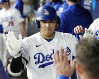 　レイズ戦の６回、15号ソロを放ち、ベンチで迎えられるドジャース・大谷＝ロサンゼルス（共同）