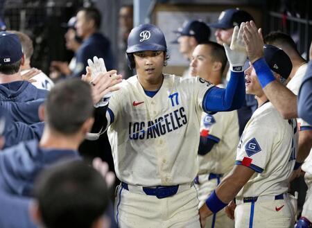 　オリオールズ戦の９回、16号ソロを放ち、ベンチで迎えられるドジャース・大谷＝ロサンゼルス（共同）