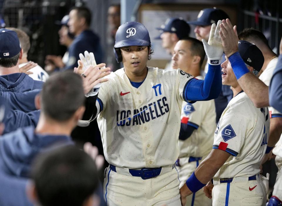 　オリオールズ戦の９回、16号ソロを放ち、ベンチで迎えられるドジャース・大谷＝ロサンゼルス（共同）