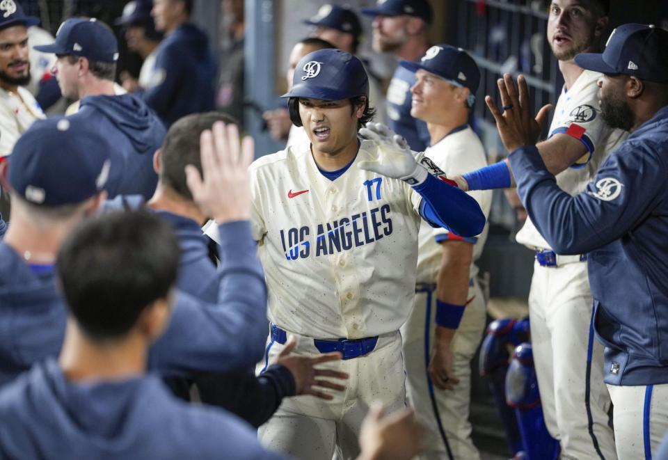 ９回、１６号ソロを放ち、ベンチで迎えられる大谷（共同）