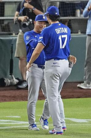 　アスレチックスに勝利し、ドジャース・大谷（手前）と喜ぶロバーツ監督＝サクラメント（共同）