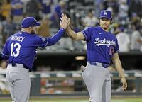 　アスレチックスに勝利し、マンシー（左）とタッチを交わすドジャース・大谷＝サクラメント（共同）