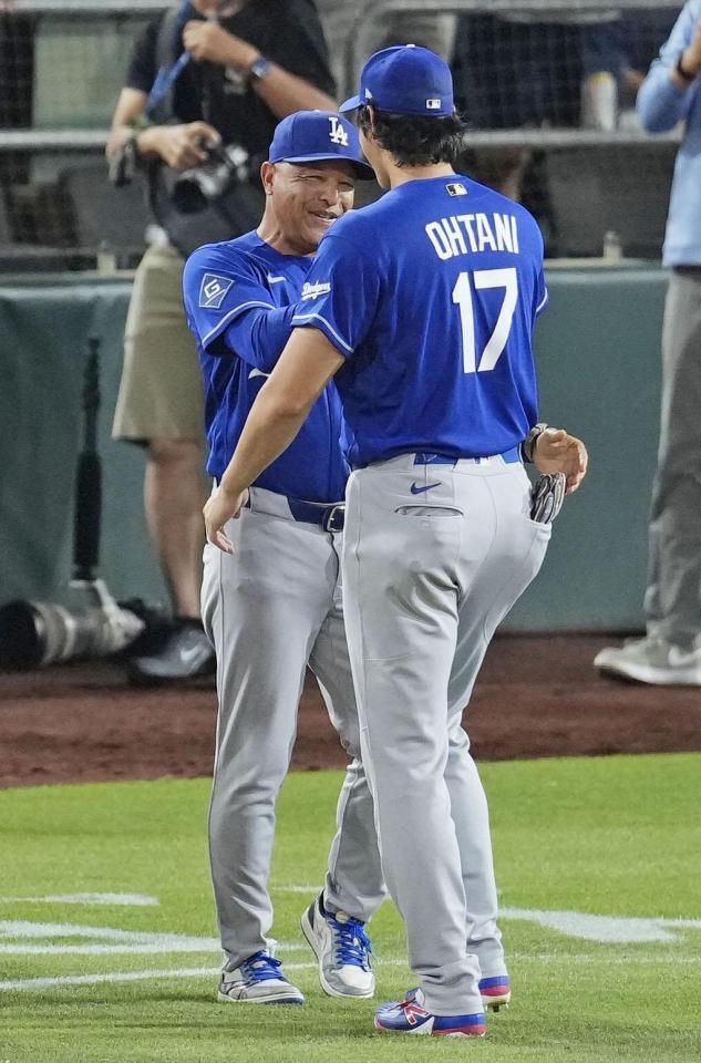 　アスレチックスに勝利し、ドジャース・大谷（手前）と喜ぶロバーツ監督＝サクラメント（共同）