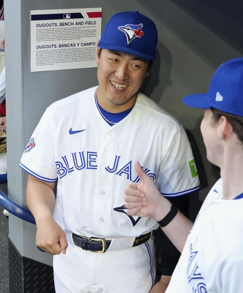 　試合前にベンチで笑顔を見せるブルージェイズ・岡本＝トロント（共同）