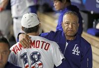 　パドレス戦に先発し、７回を無失点で投げ終え、ロバーツ監督に迎えられる山本（18）＝共同