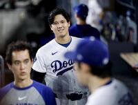 ６回、ベンチで佐々木（手前右）に声をかけるドジャース・大谷（共同）