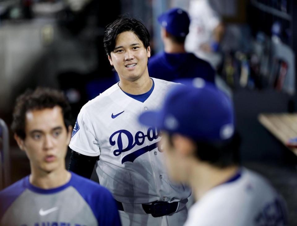 ６回、ベンチで佐々木（手前右）に声をかけるドジャース・大谷（共同）