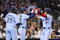 ５回、２２号３ランを放ち迎えられる岡本（右）。１８年に大谷がエンゼルスで樹立した日本勢の１年目最多記録に並んだ（ＡＰ＝共同）