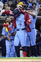 ５回、２２号３ランを放ちジャケットで祝福される岡本。１８年に大谷がエンゼルスで樹立した日本勢の１年目最多記録に並んだ（ゲッティ＝共同）
