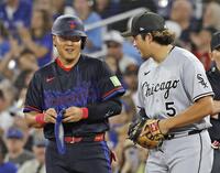 　ホワイトソックス戦の１回、死球で出塁し、一塁手村上（右）と言葉を交わす岡本（共同）