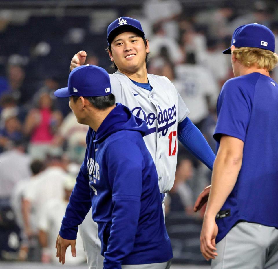 　ヤンキースに勝利し山本（手前）とタッチするドジャース・大谷（共同）
