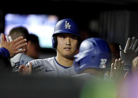 ７回、中犠飛を放ちベンチでタッチするドジャース・大谷（共同）