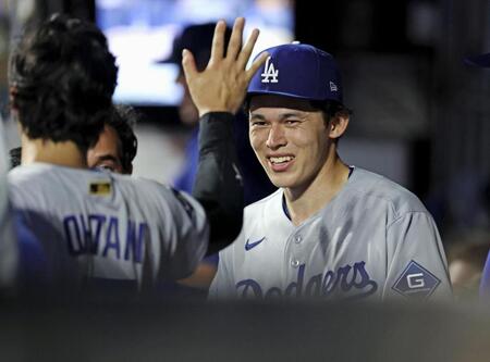 ７回を投げ終えてベンチで大谷（左）とタッチを交わすドジャース・佐々木（共同）