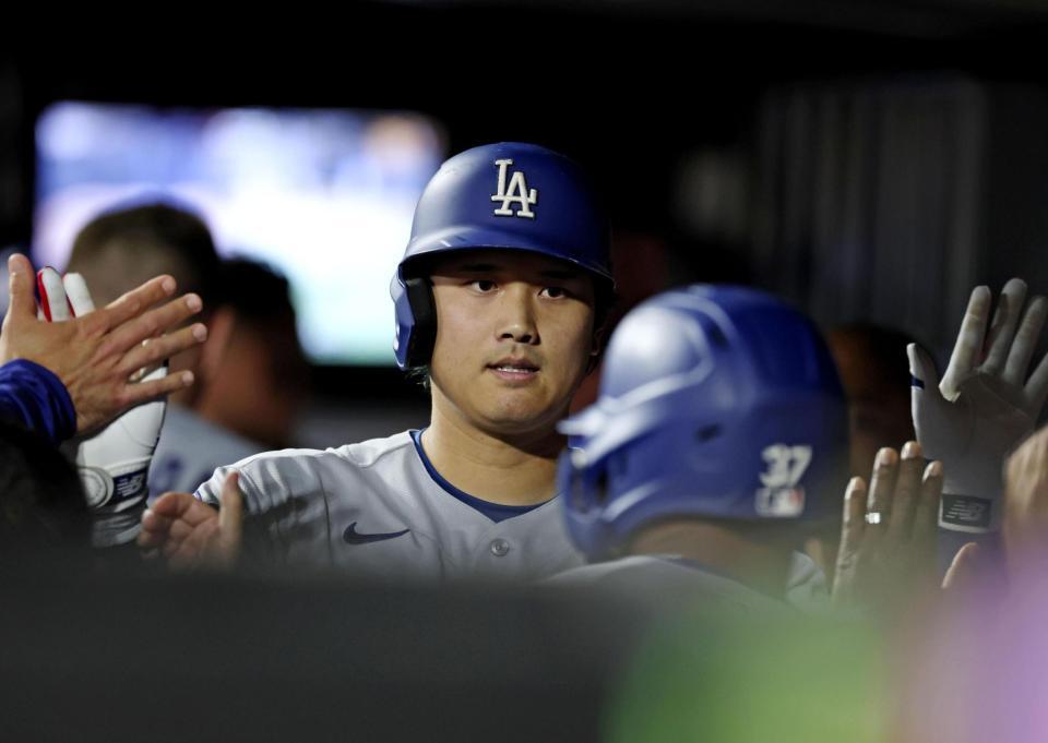 ７回、中犠飛を放ちベンチでタッチするドジャース・大谷（共同）