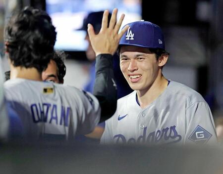 　７回を投げ終えてベンチで大谷（左）とタッチを交わすドジャース・佐々木（共同）