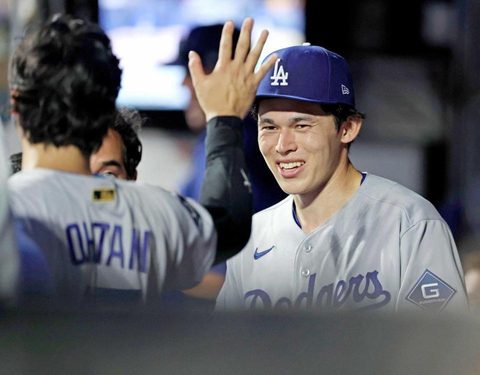 　７回を投げ終えてベンチで大谷（左）とタッチを交わすドジャース・佐々木（共同）