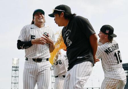 勝利し、試合後に手荒い祝福を受ける村上（左）＝共同