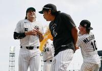 勝利し、試合後に手荒い祝福を受ける村上（左）＝共同