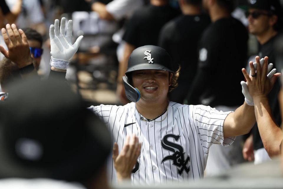 １回、２１号２ランを放ち、ベンチで迎えられる村上（共同）