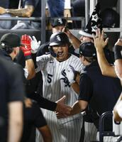 ８回、23号ソロを放ちベンチで迎えられる村上（共同）