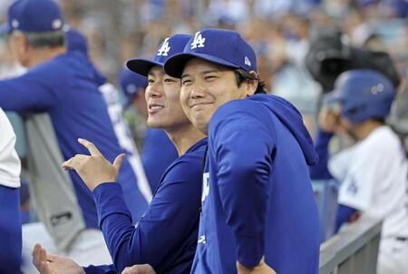 １回、ベンチで試合を見る大谷（手前）と山本（共同）