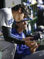 ５回、ベンチでボールを見つめる大谷（共同）