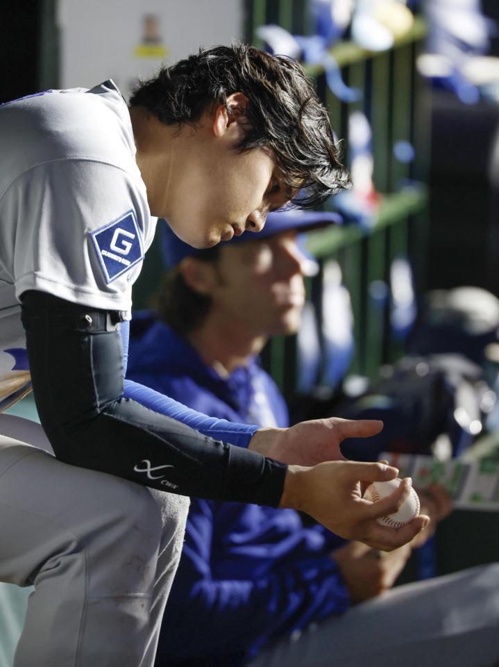 ５回、ベンチでボールを見つめる大谷（共同）