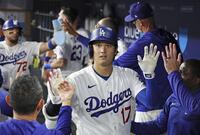 　ロイヤルズ戦の３回、27号２ランを放ち、ベンチで迎えられるドジャース・大谷＝ロサンゼルス（共同）