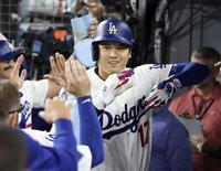 　ロイヤルズ戦の３回、27号２ランを放ち、ベンチで迎えられるドジャース・大谷＝ロサンゼルス（共同）