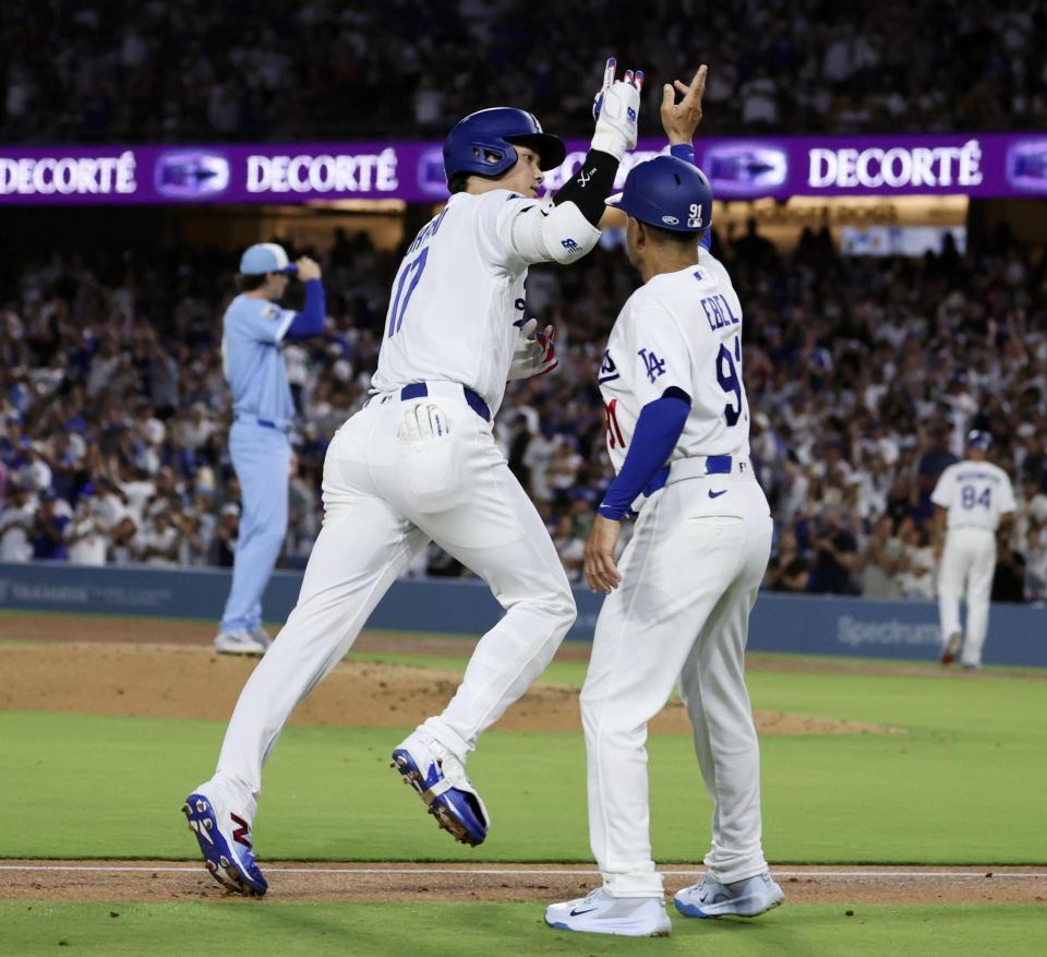 　ロイヤルズ戦の３回、27号２ランを放ち、コーチとタッチを交わすドジャース・大谷（手前左）＝ロサンゼルス（共同）