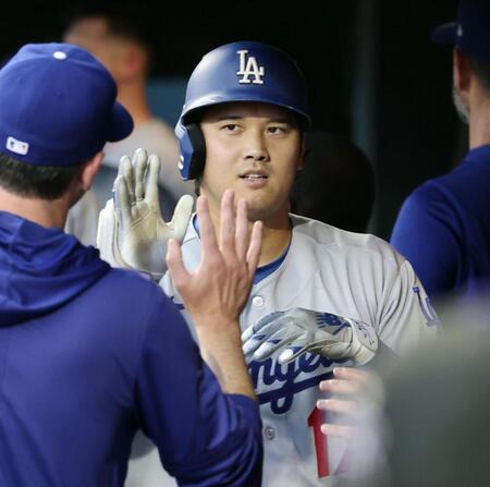 　米大リーグ、ロッキーズ戦の３回、６年連続の30本塁打となる２ランを放ち、ベンチで迎えられるドジャース・大谷翔平＝18日、デンバー（共同）
