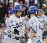　ロッキーズ戦の３回、30号２ランを放ち、パヘス（右）とタッチを交わすドジャース・大谷＝デンバー（共同）