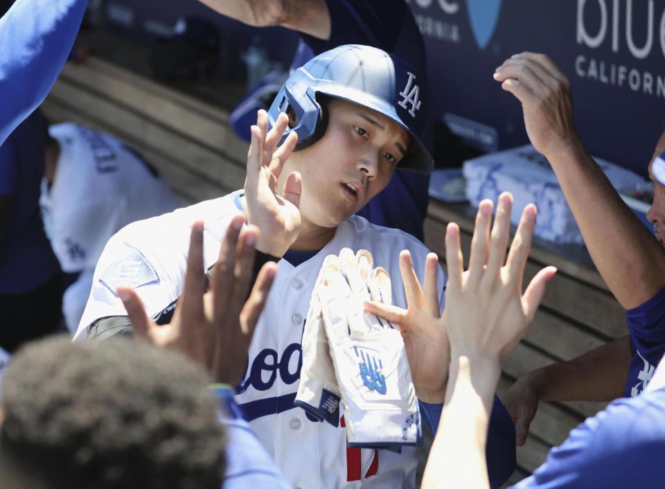 １回、後続の併殺打の間に生還しベンチで迎えられる大谷（共同）