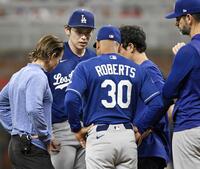 　ブレーブス戦の４回途中、ロバーツ監督（30）らと話すドジャース・佐々木朗（左から２人目）。このまま降板した＝アトランタ（共同）