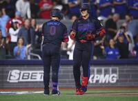 　マリナーズ戦の６回、27号ソロを放ち迎えられるブルージェイズ・岡本（右）＝トロント（ゲッティ＝共同）