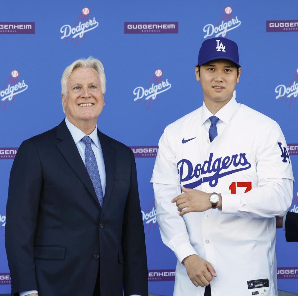 　米大リーグ、ドジャースの入団記者会見でユニホームを着た大谷翔平。左はウォルター・オーナー＝２０２３年12月、ロサンゼルスのドジャースタジアム（共同）