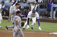 ５回、ベッツの適時二塁打で一塁から三塁へ進み、オーバーランで慌てて戻る大谷（右端）＝共同