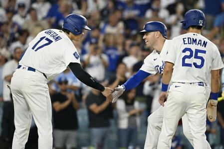 　カージナルス戦の１回、先制３ランを放ったフリーマン（中央）とタッチを交わすドジャース・大谷（左）＝ロサンゼルス（共同）