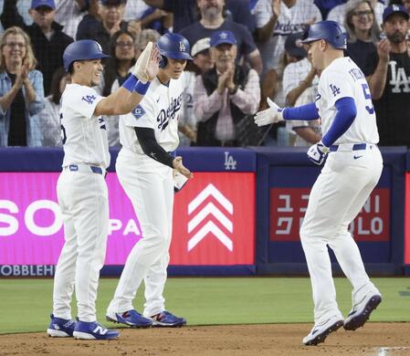 　カージナルス戦の１回、先制３ランを放ったフリーマン（右）を迎えるドジャース・大谷（中央）＝ロサンゼルス（共同）