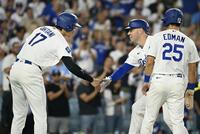 　カージナルス戦の１回、先制３ランを放ったフリーマン（中央）とタッチを交わすドジャース・大谷（左）＝ロサンゼルス（共同）