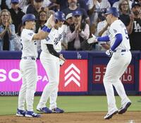 　カージナルス戦の１回、先制３ランを放ったフリーマン（右）を迎えるドジャース・大谷（中央）＝ロサンゼルス（共同）