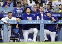 　ナショナルズ戦の９回、ベンチから試合を見るドジャース・大谷（左から２人目）と山本（右端）＝ロサンゼルス（共同）