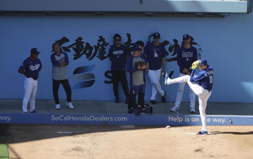 　ブルペンで投球練習するドジャース・佐々木朗。左端はロバーツ監督＝ロサンゼルス（共同）