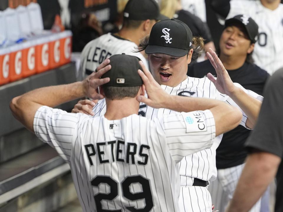 　ツインズ戦の試合前、ベンチでチームメートとポーズをとるホワイトソックス・村上＝シカゴ（共同）
