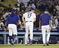 　チームメートを迎えた後、ベンチに戻るドジャース・大谷（中央）＝ロサンゼルス（共同）