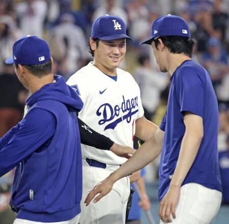 勝利し、山本（左）、佐々木（右）とタッチを交わす大谷（共同）