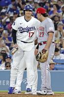 ７回、四球で出塁し、一塁手スチュワート（右）と笑顔で言葉を交わす大谷（共同）